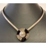A silver torque style necklace with modern design onyx set circular clasp to front.
