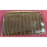 A vintage 1930's brown crocodile skin clutch bag with attached internal cosmetic mirror.