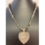 An ethnic style necklace of labradorite and white metal beads with a silver heart shaped pendant.