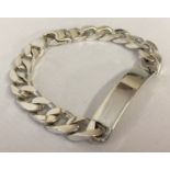 A heavy silver curb chain identity bracelet with lobster style clasp.