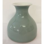 A pale green/blue glazed wide bottomed vase with signature to underside.