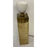 A modern design brass table lamp with upturned frosted glass lamp shade.