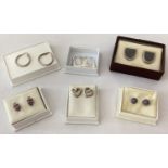 6 pairs of silver and white metal earrings in stud and hoop styles.