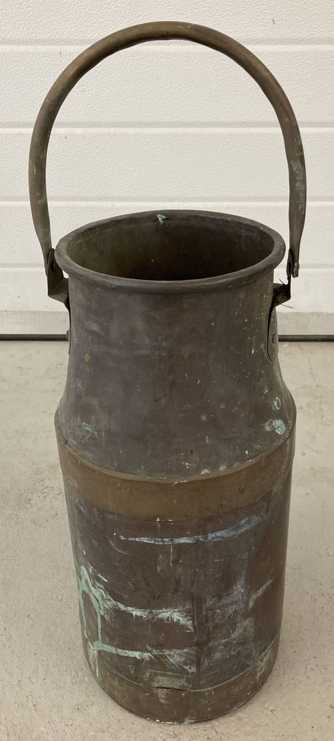 A vintage copper milk churn with brass banding and carry handle.