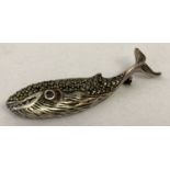 A silver brooch in the shape of a whale set with marcasite stones and an amethyst set eye.