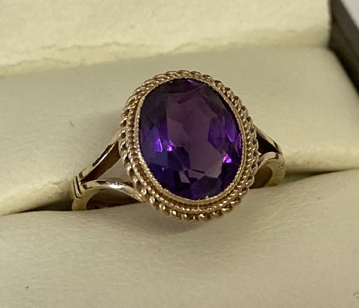 A 9ct gold 1.5ct amethyst set dress ring. Bezel set stone with rope decoration to mount.