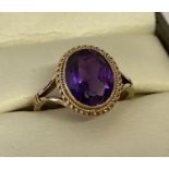 A 9ct gold 1.5ct amethyst set dress ring. Bezel set stone with rope decoration to mount.