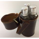 A trio of glass hip flasks in a leather case.