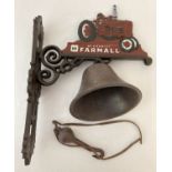 A painted cast iron wall hanging bell with "McCormick Farmall" logo and tractor.