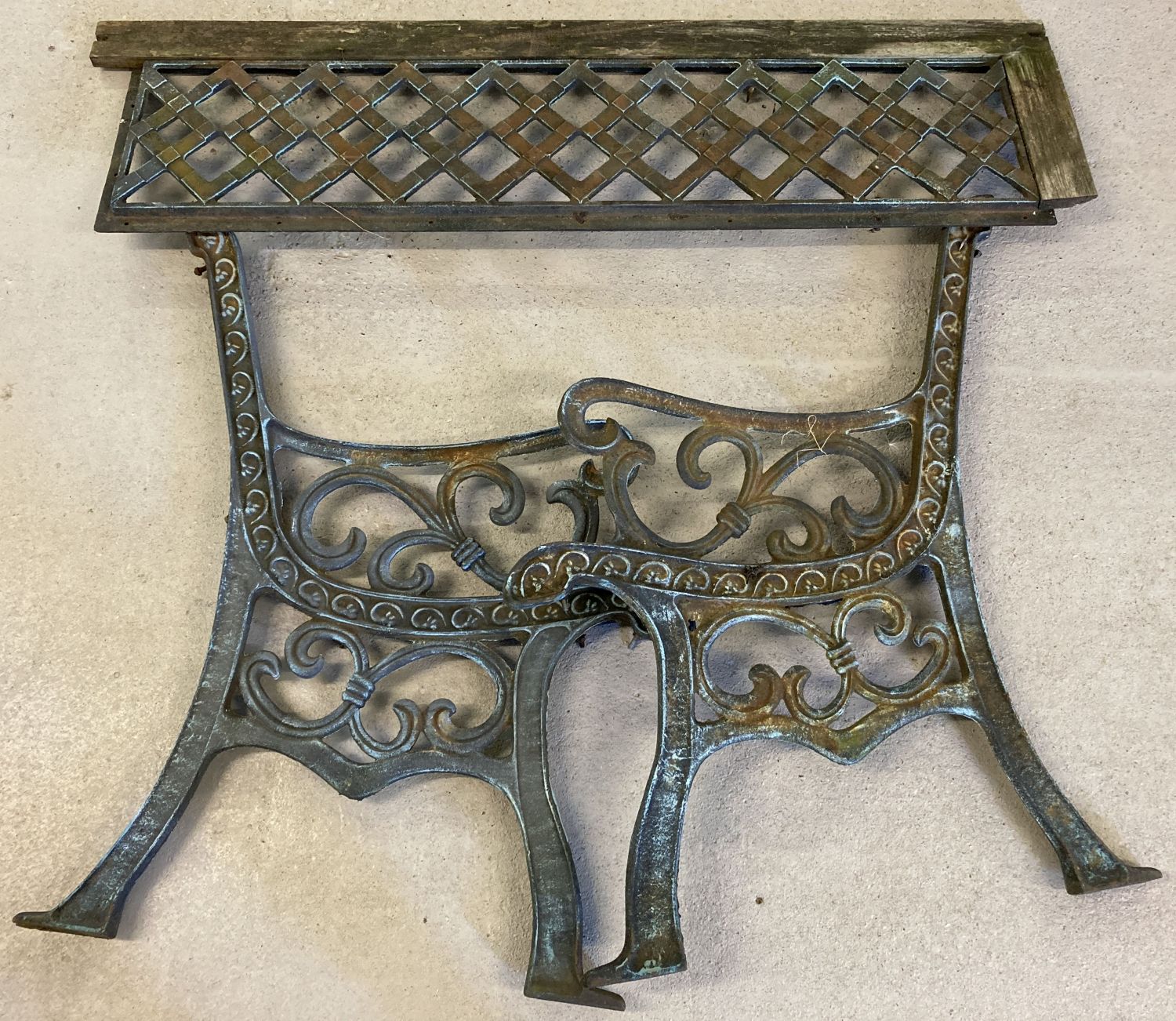 A pair of cast iron bench ends and back plate. Floral and scroll decoration to ends.