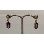 A pair of 9ct gold drop earrings set with double bullet cut amethysts.