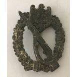 A German WWII style late war Tombac Infantry Assault pin back badge.