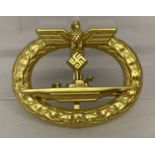 A reproduction German Kreigsmarine submarine badge in gold tone.