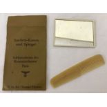 A German WWII style Officers mirror and comb set with accompanying paper packet.