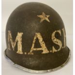 A US M1 steel helmet with hand painted M.A.S.H detail, possible film prop, complete with liner.
