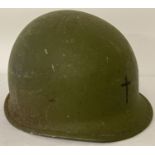 A US M1 steel helmet with Army Chaplain's cross painted on front.