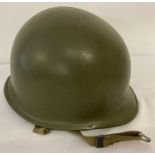 A US M1 steel helmet with repaired battle damage to rear. Helmet shell front seam, pre Nov 1944.