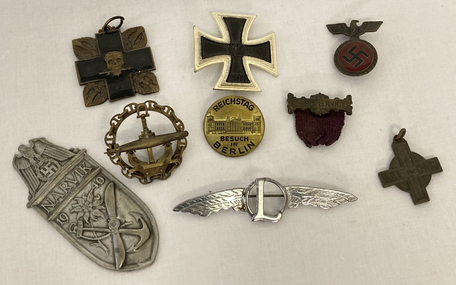 A small collection of military related badges to include German and a handmade sweetheart brooch.