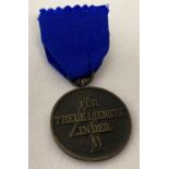 A WWII style SS 4 year service medal on blue ribbon.