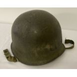 A US M1 steel helmet, painted in textural camo finish, circa Korean War.
