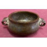 A small 2 handled Chinese bronze censer with elephant head shaped handles.