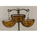 A 925 silver and amber half circle shaped pendant and matching earrings.