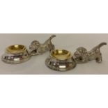 A pair of silver plated salts in the form of dogs and feeding bowls.