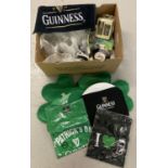 A box of Guinness merchandise. To include T-shirts, hats, bar towels, glasses and ashtrays.