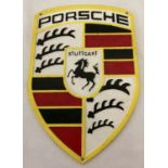 A painted cast metal shield shaped Porsche wall plaque.