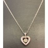 A silver fine rope chain with pierced work heart pendant set with 9 small diamonds.