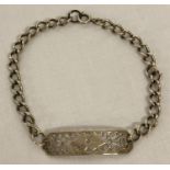 A decorative silver identity bracelet with pierced work and heart detail.
