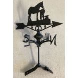 A black cast metal weather vane with blacksmith detail finial to top.