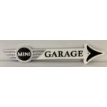 A painted cast metal Mini garage arrow wall sign.