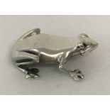 A miniature sterling silver figure of a frog.