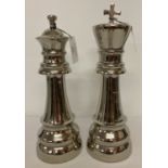 A pair of modern white metal chess piece figurines.