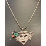 A white metal masquerade mask pendant with natural stone bead detail on a silver wheat style chain.