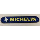 A curve ended, painted cast metal wall plaque for Michelin tyres.