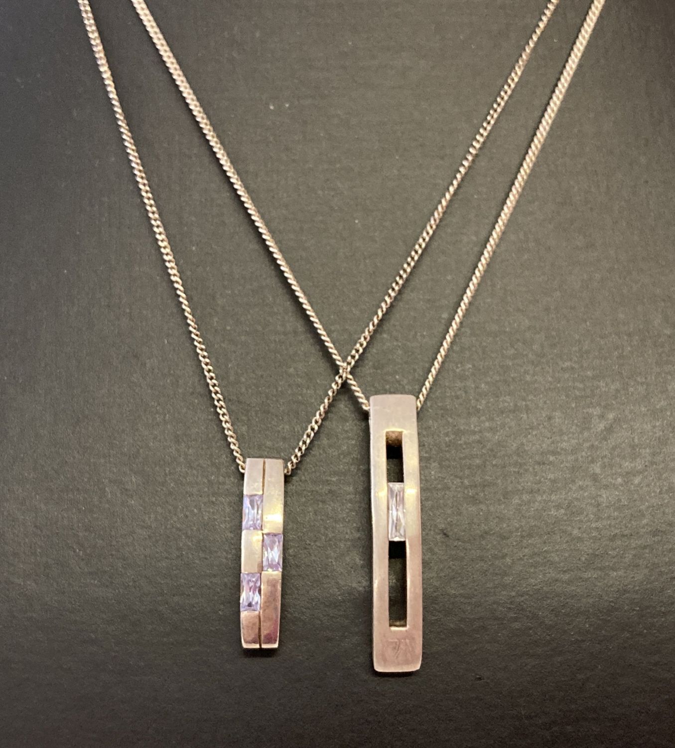 2 modern design silver necklaces. A fine curb chain with rectangular drop pendant set with a clear