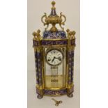 A large ornate brass and cloisonné wind up mantle clock with swing pendulum movement.