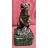 A bronze figurine of a bear on a green marble base.
