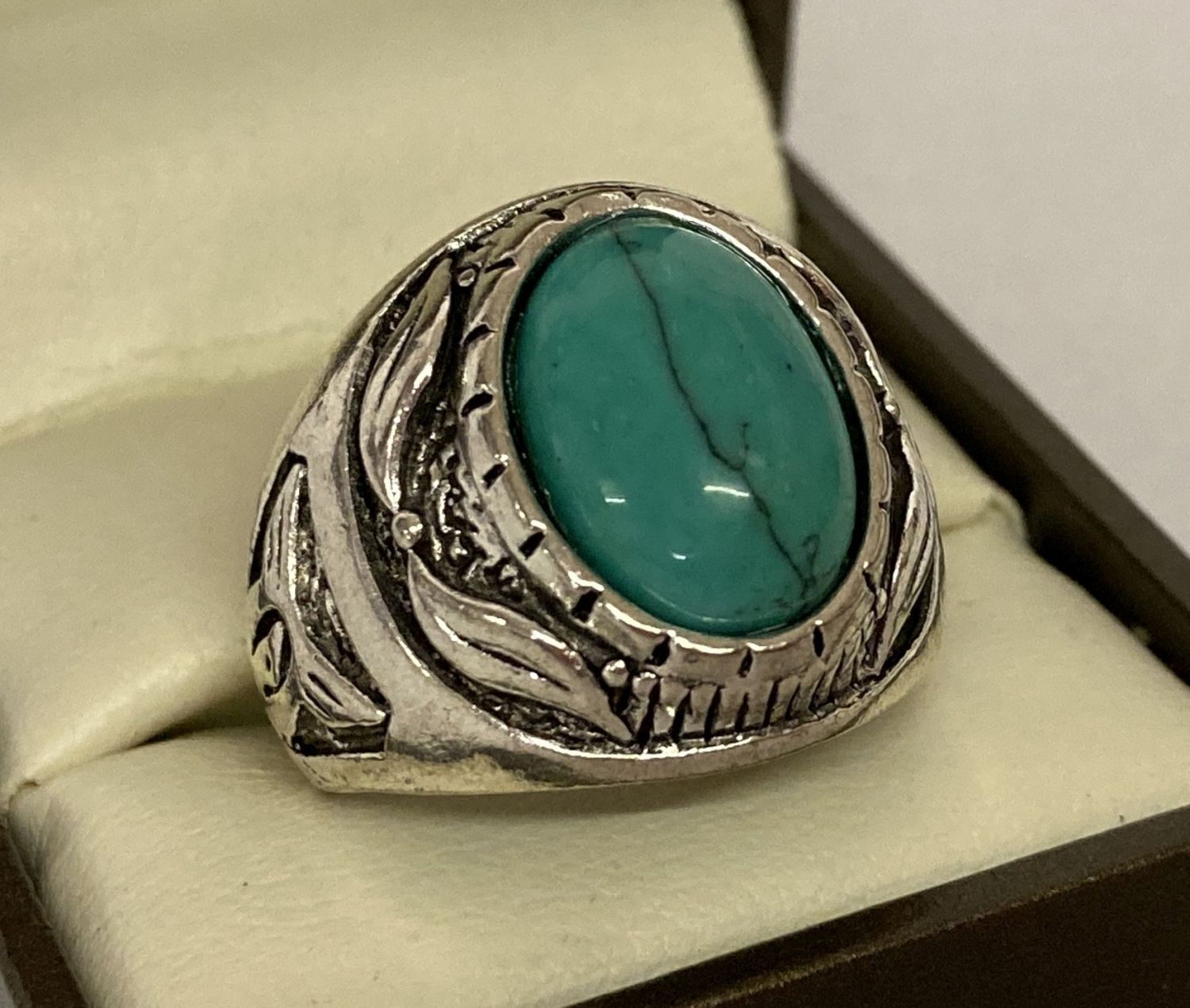 A chunky white metal dress ring set with oval turquoise cabochon.