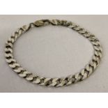 A silver curb chain bracelet with lobster style clasp.