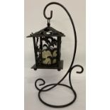 A decorative cast iron, free standing, garden candle lantern and stand.