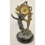 A vintage Art Nouveau style table/mantle clock with cherub figure and iris flower decoration.