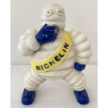 A painted cast iron figurine of Michelin man smoking.