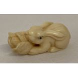 A small signed Netsuke carved into the form of a rabbit with a cabbage.