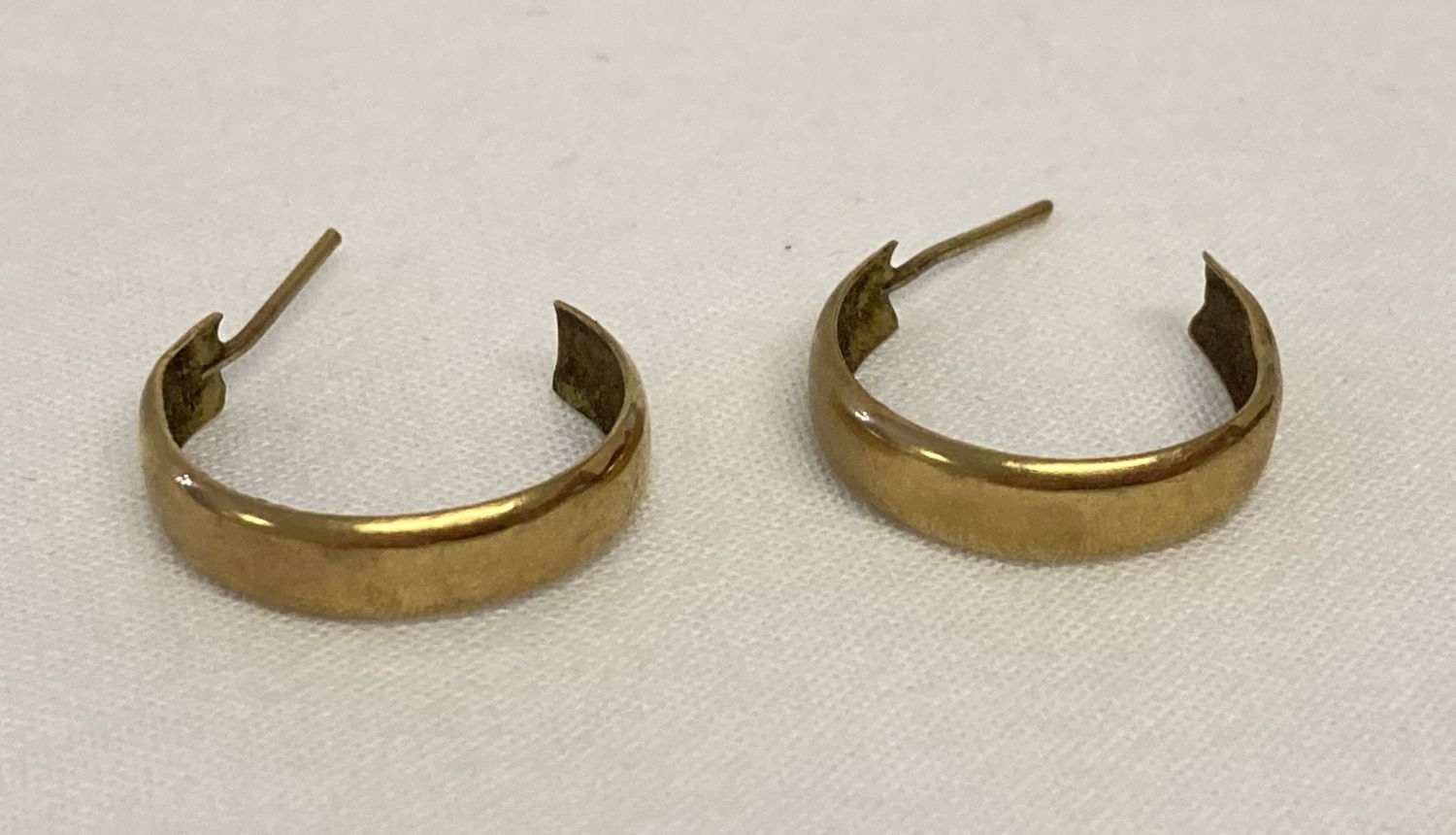 A pair of 9ct gold half hoop style earrings without butterfly backs.
