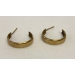 A pair of 9ct gold half hoop style earrings without butterfly backs.