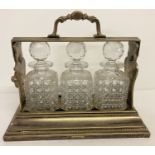 A Betjemann's Patent silver plated "The Tantalus" with 3 hobnail design cut glass decanters.