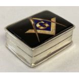 A small white metal pill box marked "Sterling" with ceramic plaque to lid showing Masonic symbol.